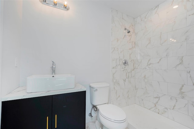 bathroom with tiled shower, toilet, and vanity