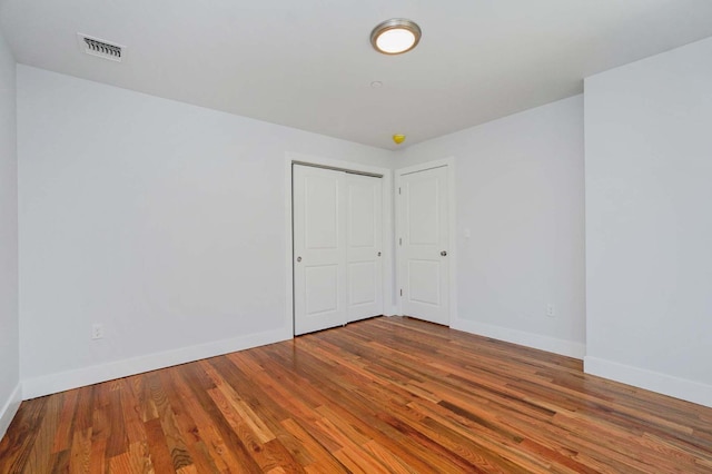spare room featuring wood finished floors and baseboards