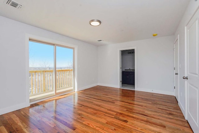 spare room with wood finished floors and baseboards