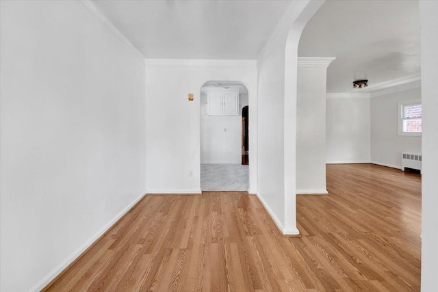 1230 Arnow Ave, Bronx, NY 10469 - spare room featuring arched walkways, radiator heating unit, crown molding, wood finished floors, and baseboards