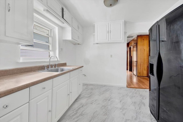 1230 Arnow Ave, Bronx, NY 10469 - kitchen featuring black fridge with ice dispenser, a sink, white cabinetry, and light countertops