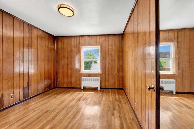 1230 Arnow Ave, Bronx, NY 10469 - spare room with radiator, light wood-style flooring, and wood walls