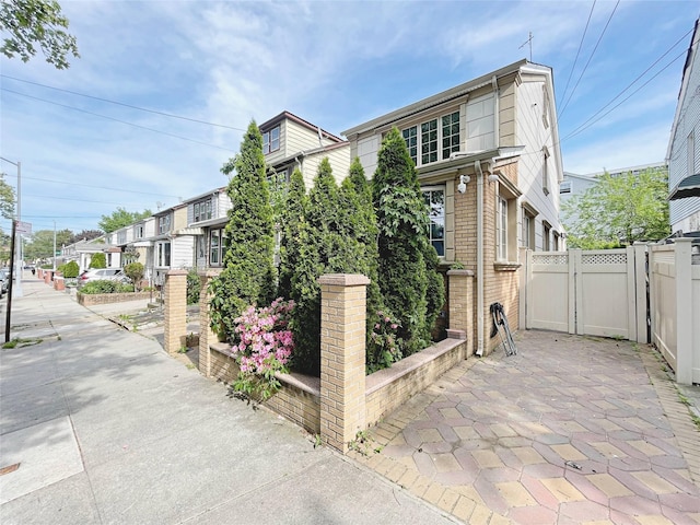 15204 79th Ave, Kew Garden Hills, NY 11367 - view of home's exterior with a gate, fence, and brick siding