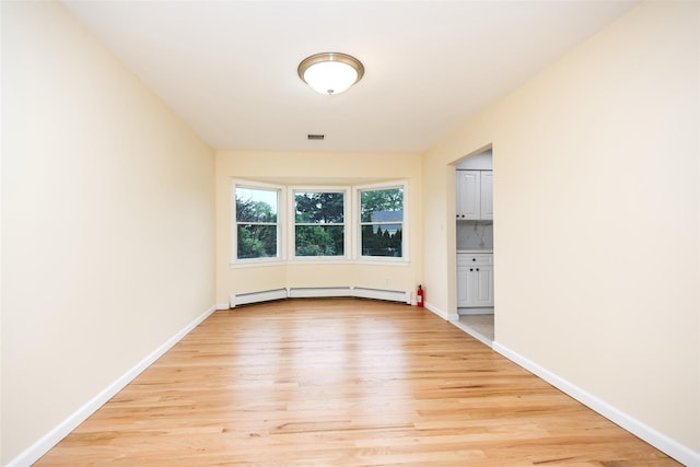 247 Marcus Ave, New Hyde Park, NY 11040 - spare room featuring light wood-style flooring, baseboards, and a baseboard radiator