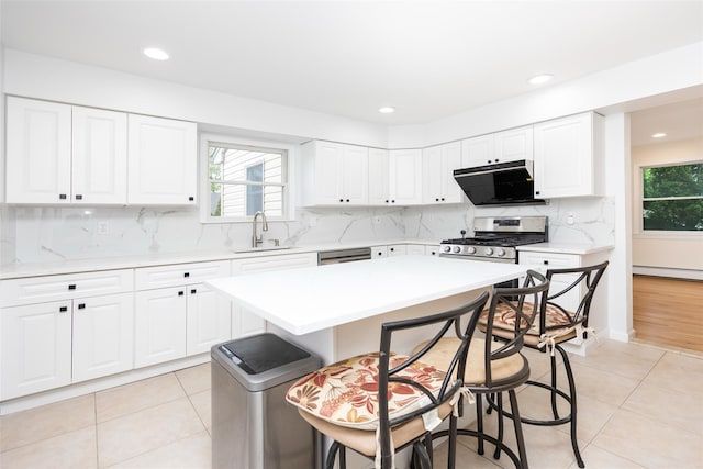 247 Marcus Ave, New Hyde Park, NY 11040 - kitchen with a sink, stainless steel appliances, a kitchen breakfast bar, light countertops, and recessed lighting