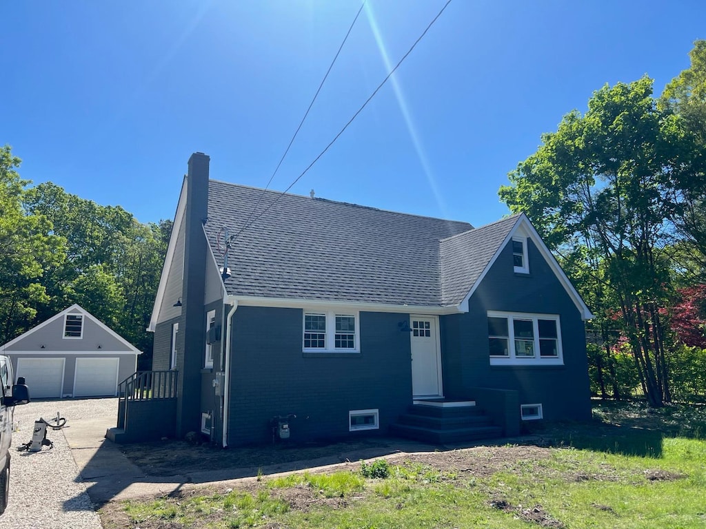 381 Wading River Rd, Manorville, NY 11949 - view of front of house with a garage, an outdoor structure, a shingled roof, a chimney, and entry steps