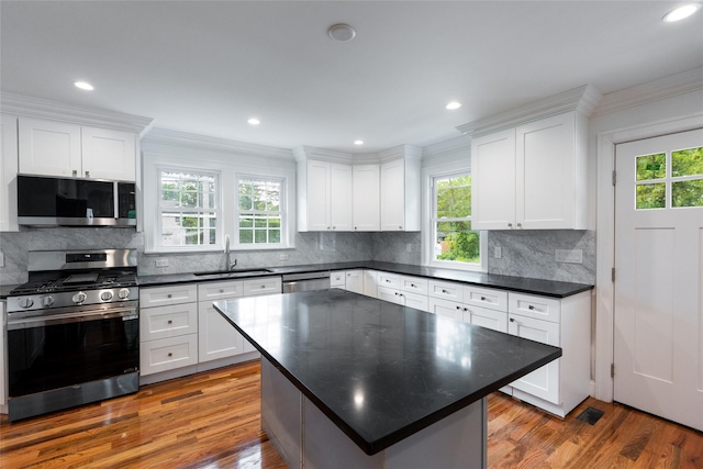 381 Wading River Rd, Manorville, NY 11949 - kitchen with stainless steel appliances, a sink, plenty of natural light, white cabinets, and ornamental molding