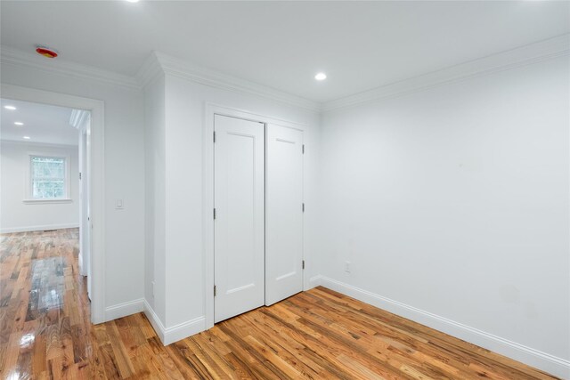 381 Wading River Rd, Manorville, NY 11949 - unfurnished bedroom with baseboards, light wood-style floors, a closet, crown molding, and recessed lighting