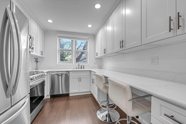 1390 Broadway Unit 107, Hewlett, NY 11557 - kitchen with appliances with stainless steel finishes, a sink, white cabinets, recessed lighting, and light stone counters