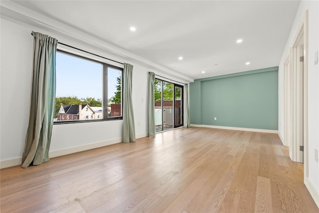 spare room featuring recessed lighting, light wood finished floors, and baseboards