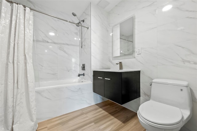 full bath featuring tile walls, shower / bath combo with shower curtain, toilet, and vanity