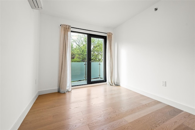 empty room featuring wood finished floors, baseboards, and a pendent fire sprinkler