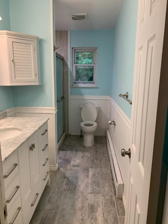 5-7 Barbara Ln, Farmingdale, NY 11735 - full bath featuring baseboard heating, a wainscoted wall, a stall shower, toilet, and vanity