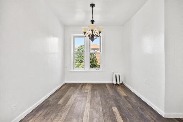 unfurnished dining area with radiator, a chandelier, wood finished floors, and baseboards