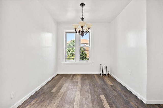 unfurnished dining area with radiator heating unit, a chandelier, dark wood finished floors, and baseboards