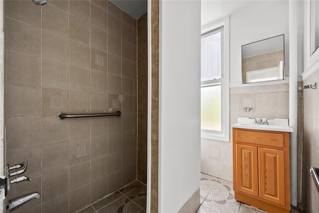 full bath with tile walls, a tile shower, tile patterned floors, and vanity