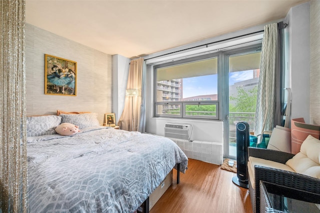 bedroom with wood finished floors and a wall mounted AC
