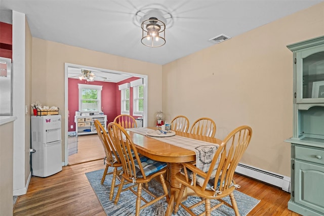149 E Main St, Washingtonville, NY 10992 - dining space with a baseboard radiator, light wood-style flooring, and ceiling fan