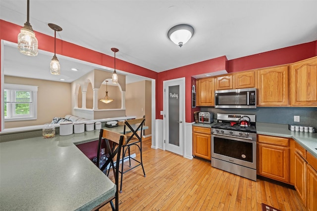 149 E Main St, Washingtonville, NY 10992 - kitchen featuring stainless steel appliances, light wood-style flooring, pendant lighting, light countertops, and brown cabinetry