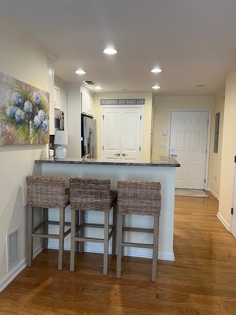 1105 Round Pointe Dr, Haverstraw, NY 10927 - kitchen featuring stainless steel appliances, a breakfast bar, wood finished floors, baseboards, and a peninsula