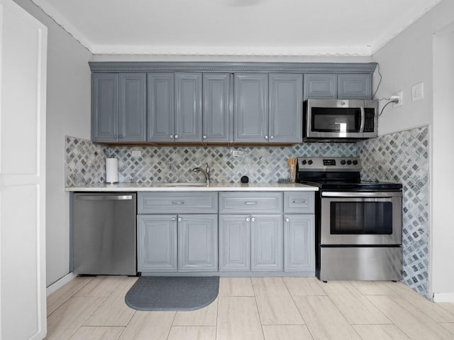 33 Saddle Ln, Levittown, NY 11756 - kitchen with appliances with stainless steel finishes, light countertops, decorative backsplash, a sink, and crown molding