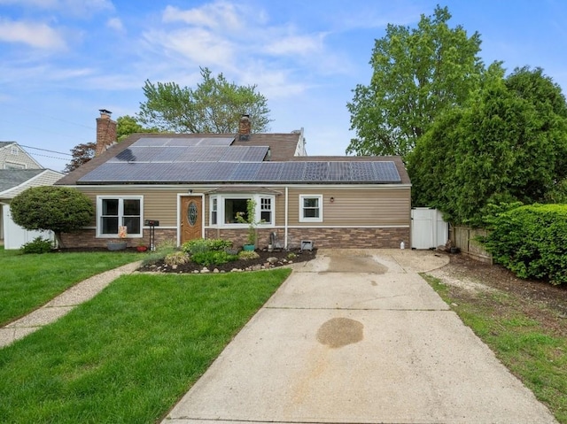 33 Saddle Ln, Levittown, NY 11756 - view of front facade with a chimney, solar panels, and driveway