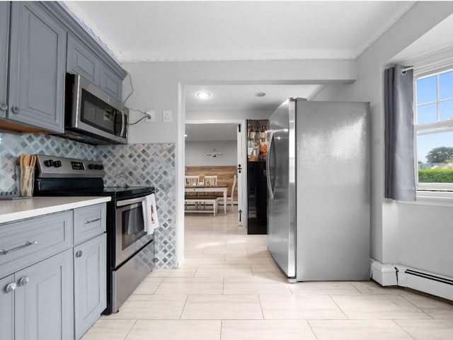 33 Saddle Ln, Levittown, NY 11756 - kitchen featuring stainless steel appliances, tasteful backsplash, baseboard heating, and light countertops