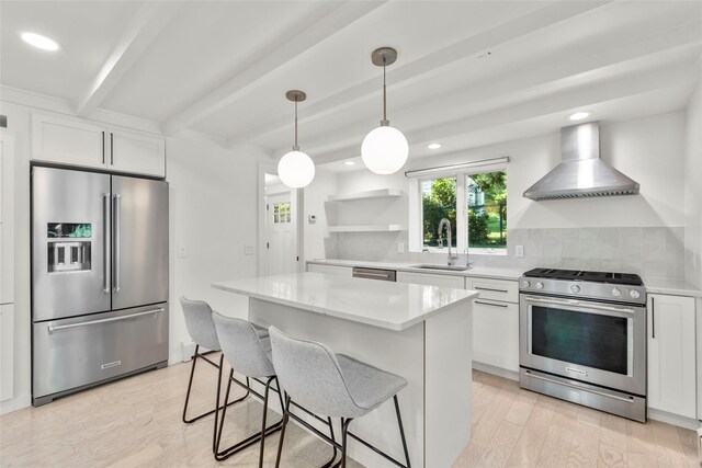 51/2 Locust Ave, Stony Brook, NY 11790 - kitchen featuring stainless steel appliances, wall chimney range hood, beam ceiling, a sink, and white cabinetry