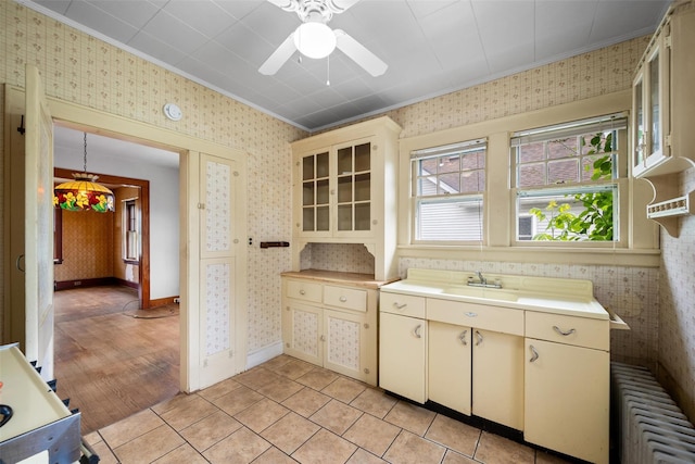 16 Oak Ter, Suffern, NY 10901 - kitchen featuring radiator, cream cabinets, ornamental molding, wallpapered walls, and light countertops