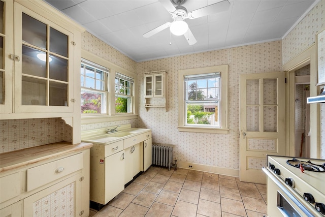 16 Oak Ter, Suffern, NY 10901 - kitchen featuring radiator heating unit, cream cabinets, wallpapered walls, white gas stove, and ornamental molding