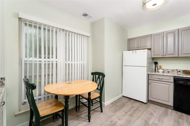 kitchen with freestanding refrigerator, black dishwasher, gray cabinetry, light wood-style floors, and baseboards