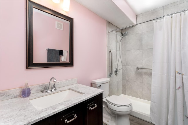 full bath with toilet, a tile shower, and vanity