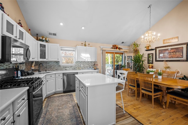 178 Prospect Pl, Bay Shore, NY 11706 - kitchen featuring black gas range oven, dishwasher, a sink, a chandelier, and a kitchen breakfast bar