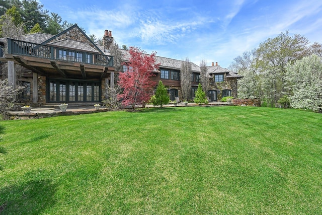 118 John St, Greenwich, CT 06831 - rear view of property with a yard, stone siding, a chimney, and a wooden deck