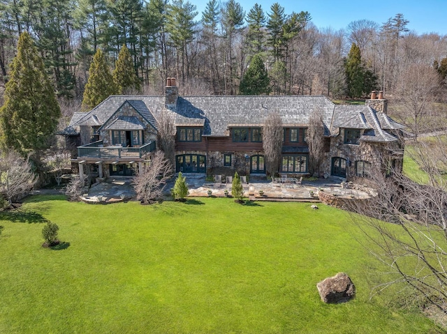 118 John St, Greenwich, CT 06831 - back of property featuring a chimney, a lawn, a patio, a balcony, and stone siding
