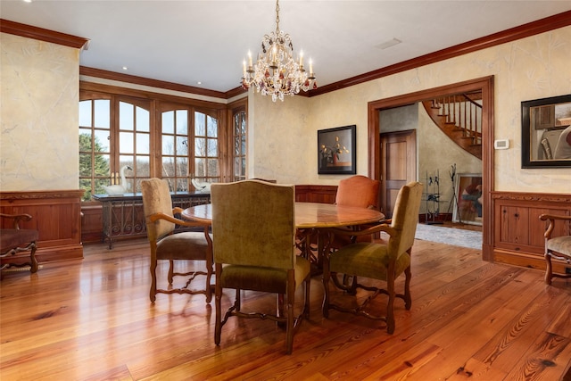 118 John St, Greenwich, CT 06831 - dining room featuring crown molding, wood finished floors, a chandelier, a wainscoted wall, and stairs