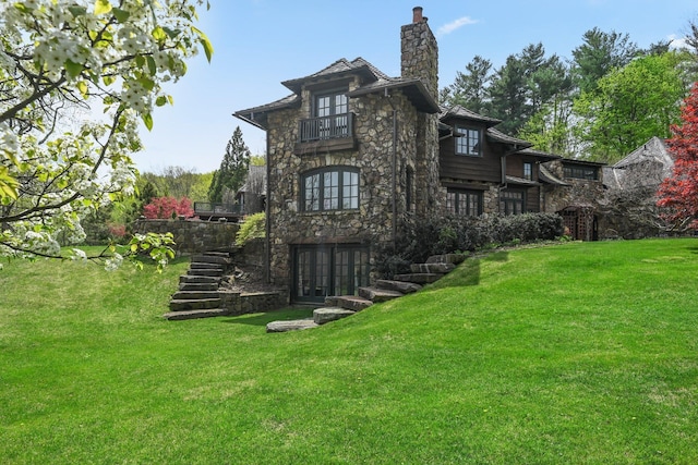 118 John St, Greenwich, CT 06831 - rear view of house featuring stone siding, a yard, a balcony, stairs, and a chimney
