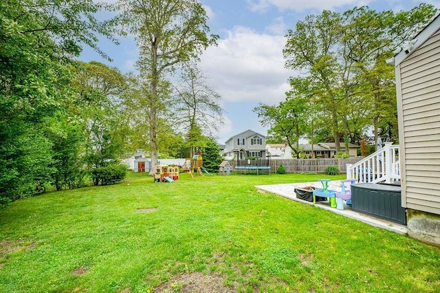 view of yard featuring a playground, a trampoline, and a patio