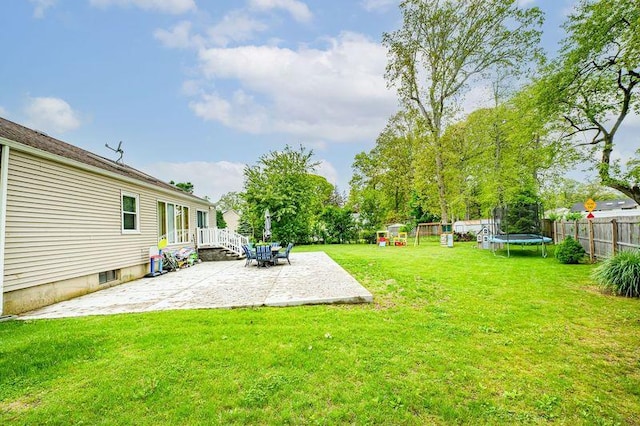 view of yard featuring a trampoline and a patio