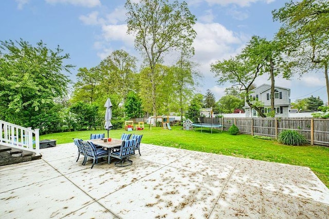 view of patio featuring a trampoline, a playground, and outdoor dining area