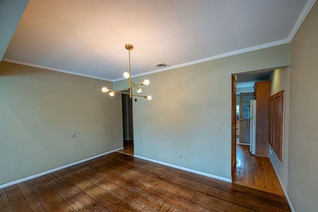 unfurnished room with hardwood / wood-style flooring, a chandelier, ornamental molding, and baseboards