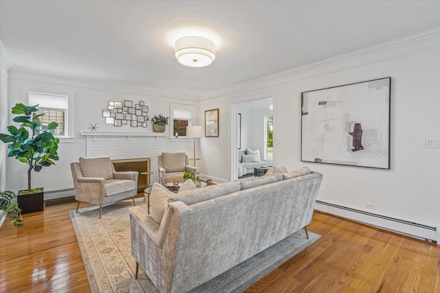 living room featuring baseboard heating, wood-type flooring, and ornamental molding