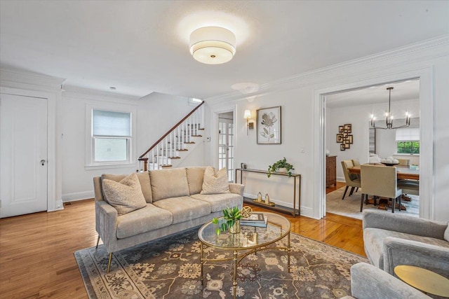 living area featuring stairway, crown molding, healthy amount of natural light, and wood finished floors