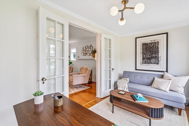 living area with crown molding, wood finished floors, and french doors