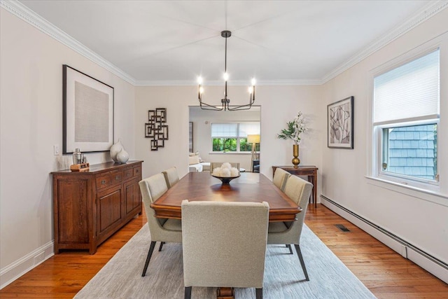 dining area with a baseboard heating unit, light wood-style flooring, crown molding, a chandelier, and baseboards