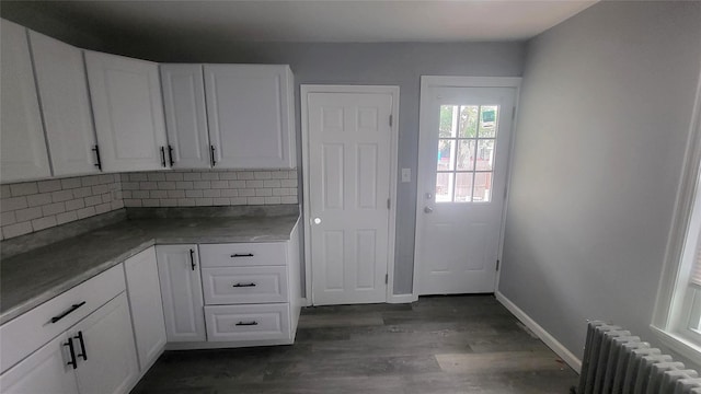 164 Thompson St, Poughkeepsie, NY 12601 - kitchen featuring radiator heating unit, decorative backsplash, white cabinets, and dark wood-style flooring