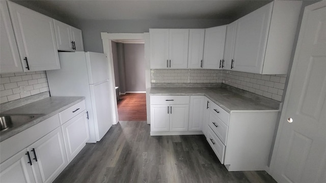 164 Thompson St, Poughkeepsie, NY 12601 - kitchen with dark wood-type flooring, white cabinetry, decorative backsplash, light countertops, and a sink