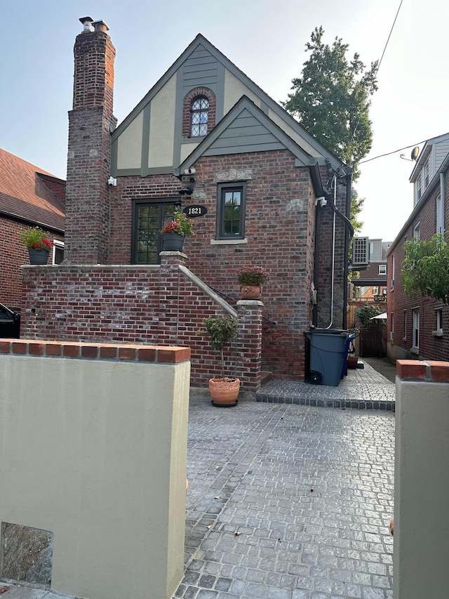 1821 Tenbroeck Ave, Bronx, NY 10461 - view of front of home with brick siding, a patio area, and a chimney