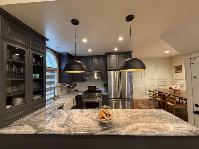 1821 Tenbroeck Ave, Bronx, NY 10461 - kitchen with premium appliances, under cabinet range hood, a sink, backsplash, and light stone countertops