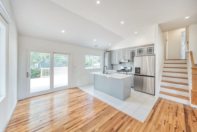 48 Hillside Ave, Patchogue, NY 11772 - kitchen with appliances with stainless steel finishes, light wood-style flooring, a sink, under cabinet range hood, and lofted ceiling